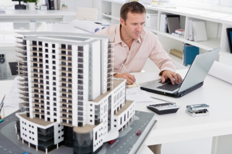 Man using laptop next to scale model